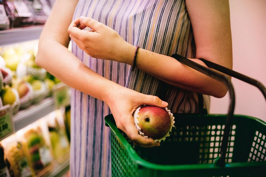 אשה קונה מנגו בסופרמרקט