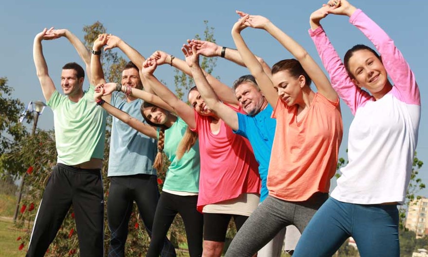 מבוגרים וצעירים מבצעים פעילות גופנית בחוץ
