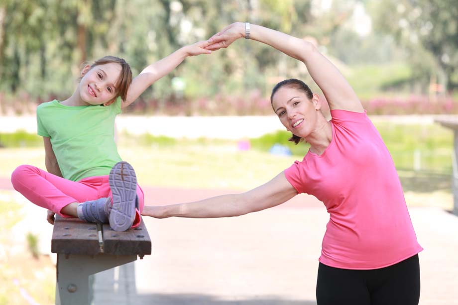 Mother and daughter exercising in the park