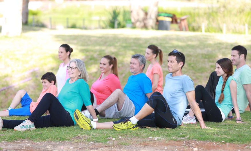 Children and adults exercising in the park