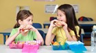 Girls eating sandwiches in class