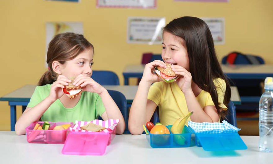 Girls eating sandwiches in class