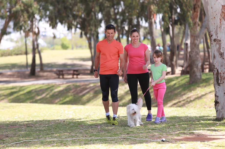 משפחה מטיילת בפארק עם הכלב